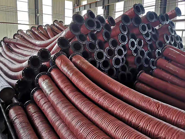 A pile of red mud rubber hoses are stored in the warehouse.